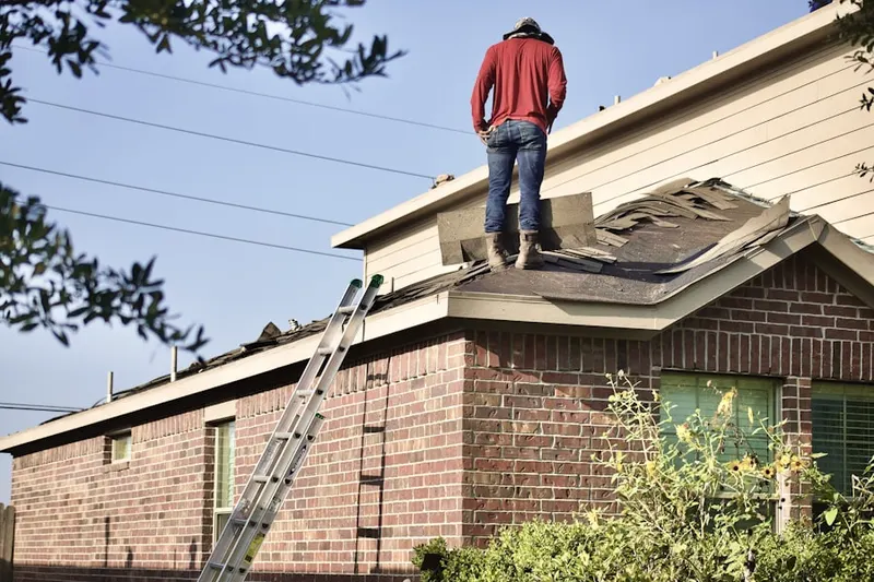 Professional roofer working on a residential roof in Riverton East